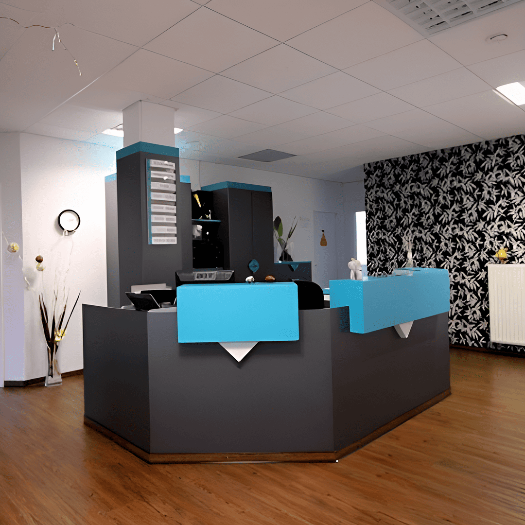 Empfangsbereich der Zahnarztpraxis Bär in Bitterfeld-Wolfen mit modernem Design, blauen Akzenten und einer stilvollen Tapetenwand im Hintergrund. Der Empfang bietet eine freundliche und professionelle Atmosphäre für Patienten bei ihrer Ankunft.